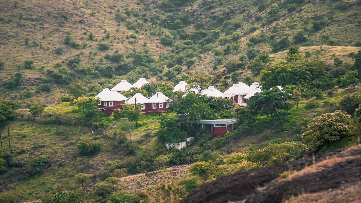a group of houses sitting on top of a lush green hillside