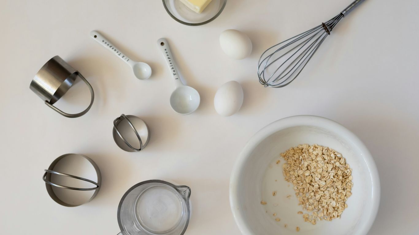 Baking ingredients and tools arranged on a white surface.