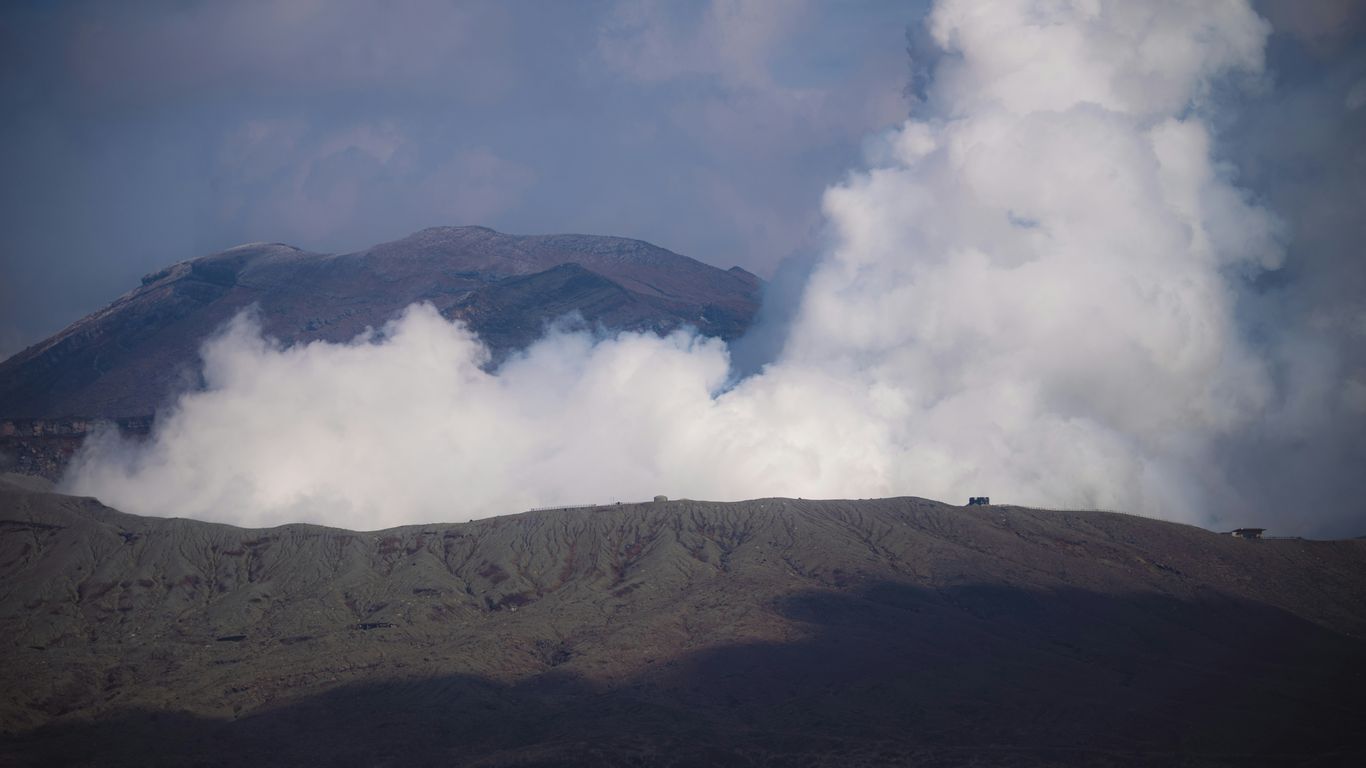a view of a mountain with clouds coming out of it