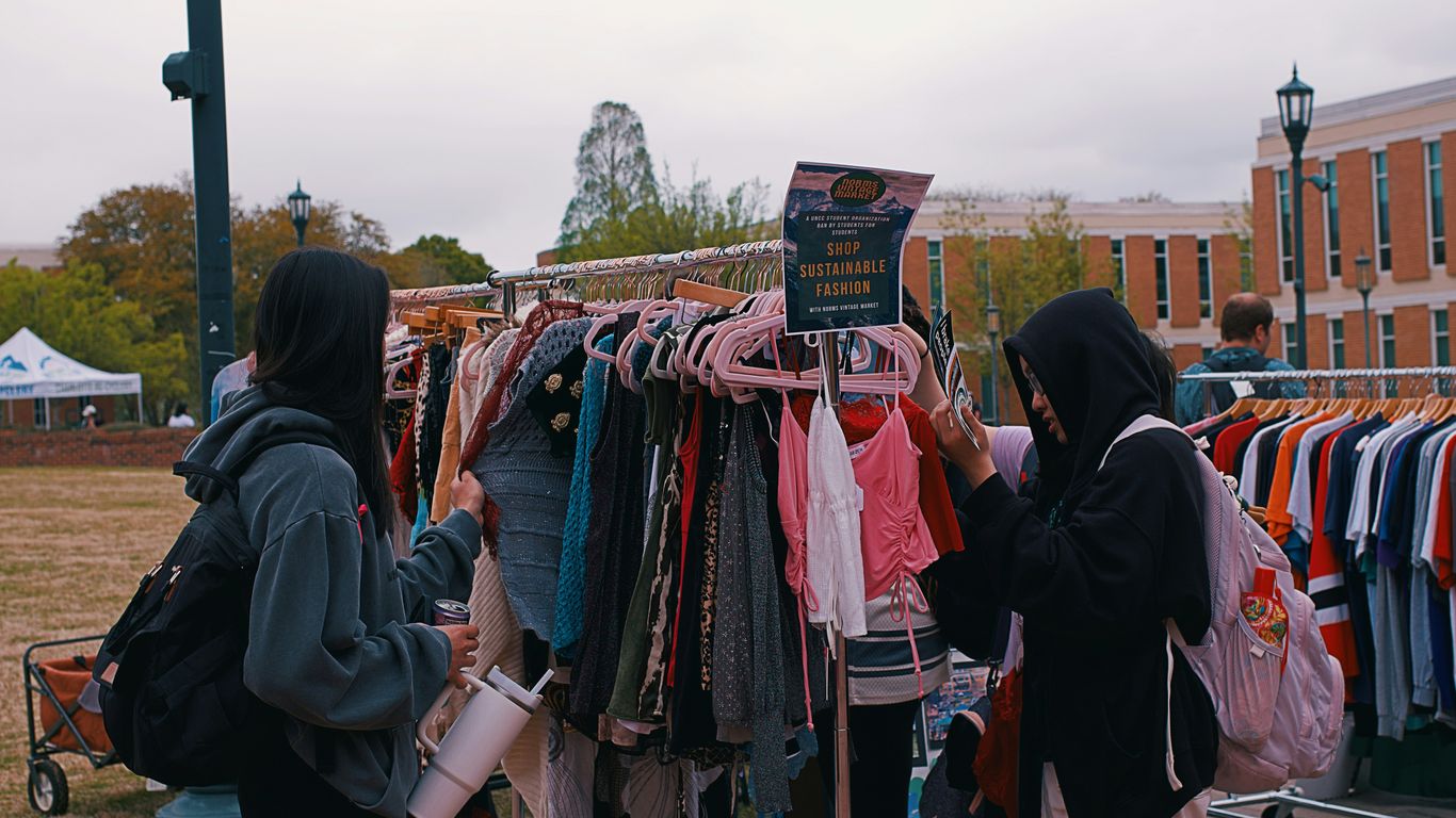 People browse clothes at an outdoor pop-up shop.