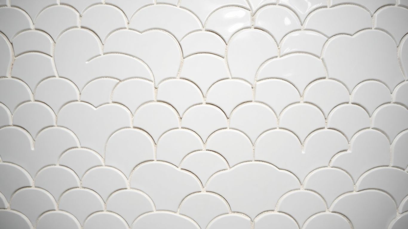 White arabesque tile with intricate geometric pattern.
