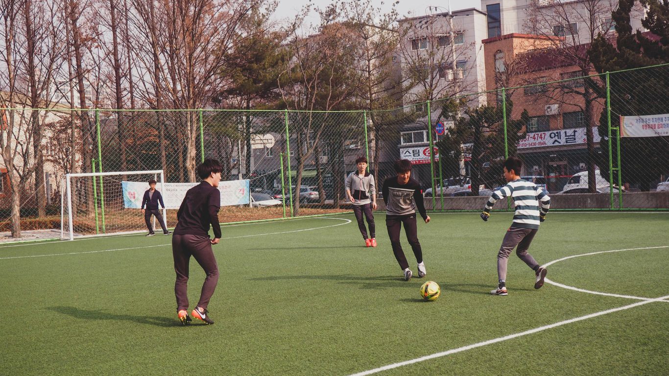 boys playing soccer on field