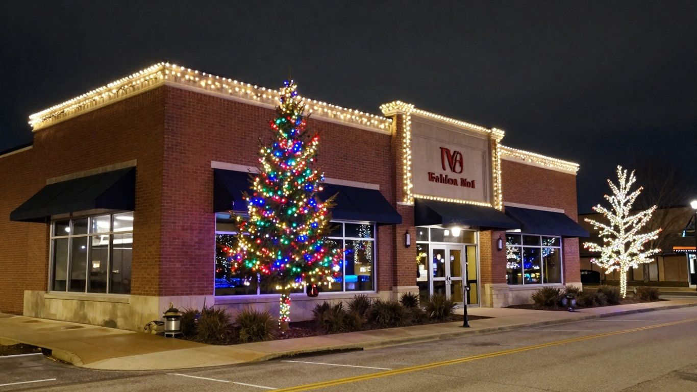 Commercial building decorated with bright Christmas lights at night.