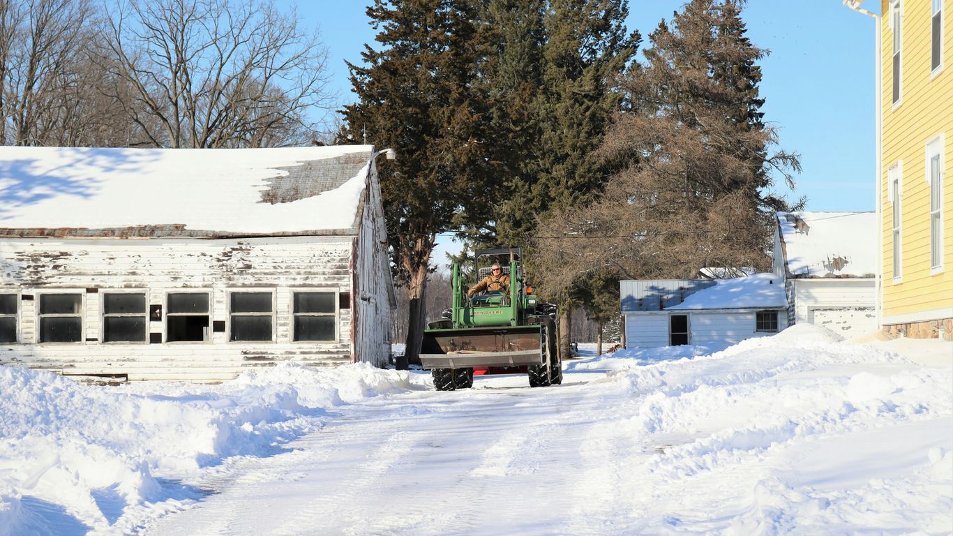 a truck driving down a snow covered road