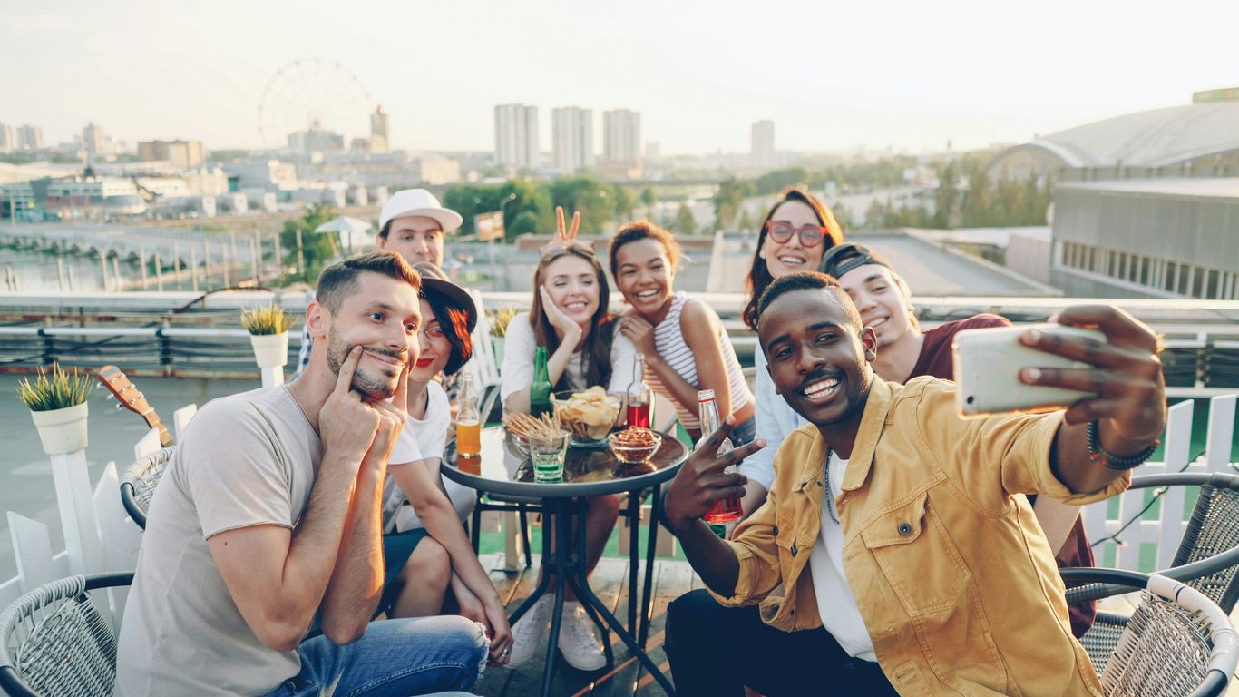 Group of friends taking a selfie on a rooftop.