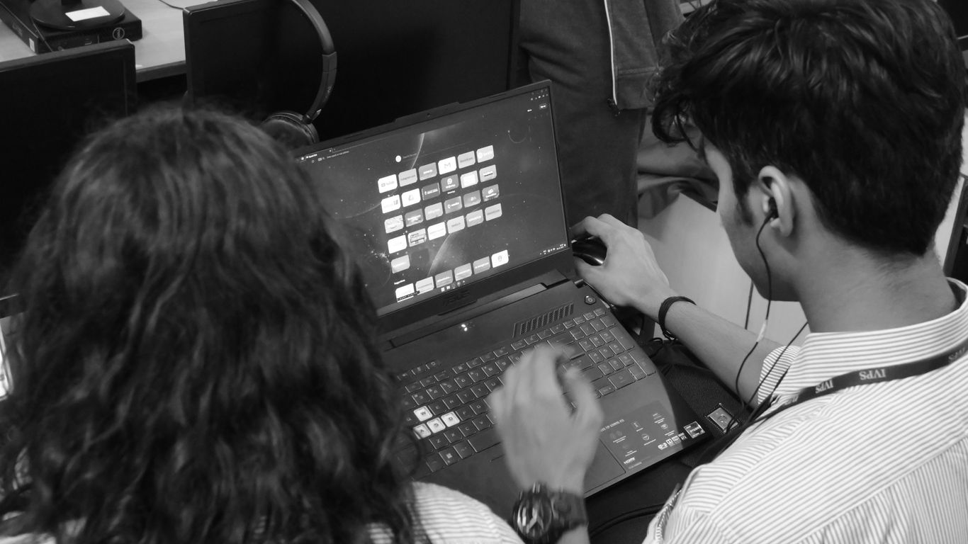 a man and a woman sitting in front of a laptop computer