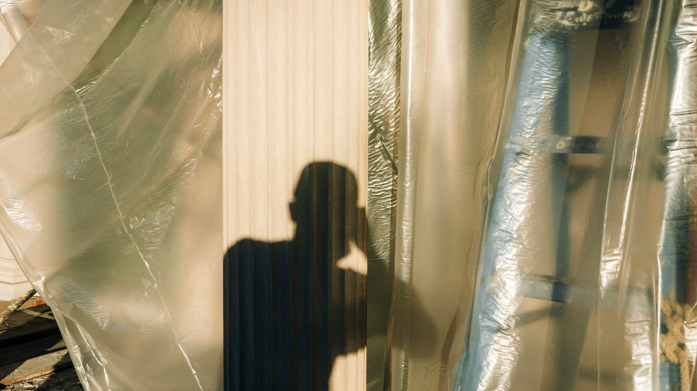 woman in black dress standing in front of glass window