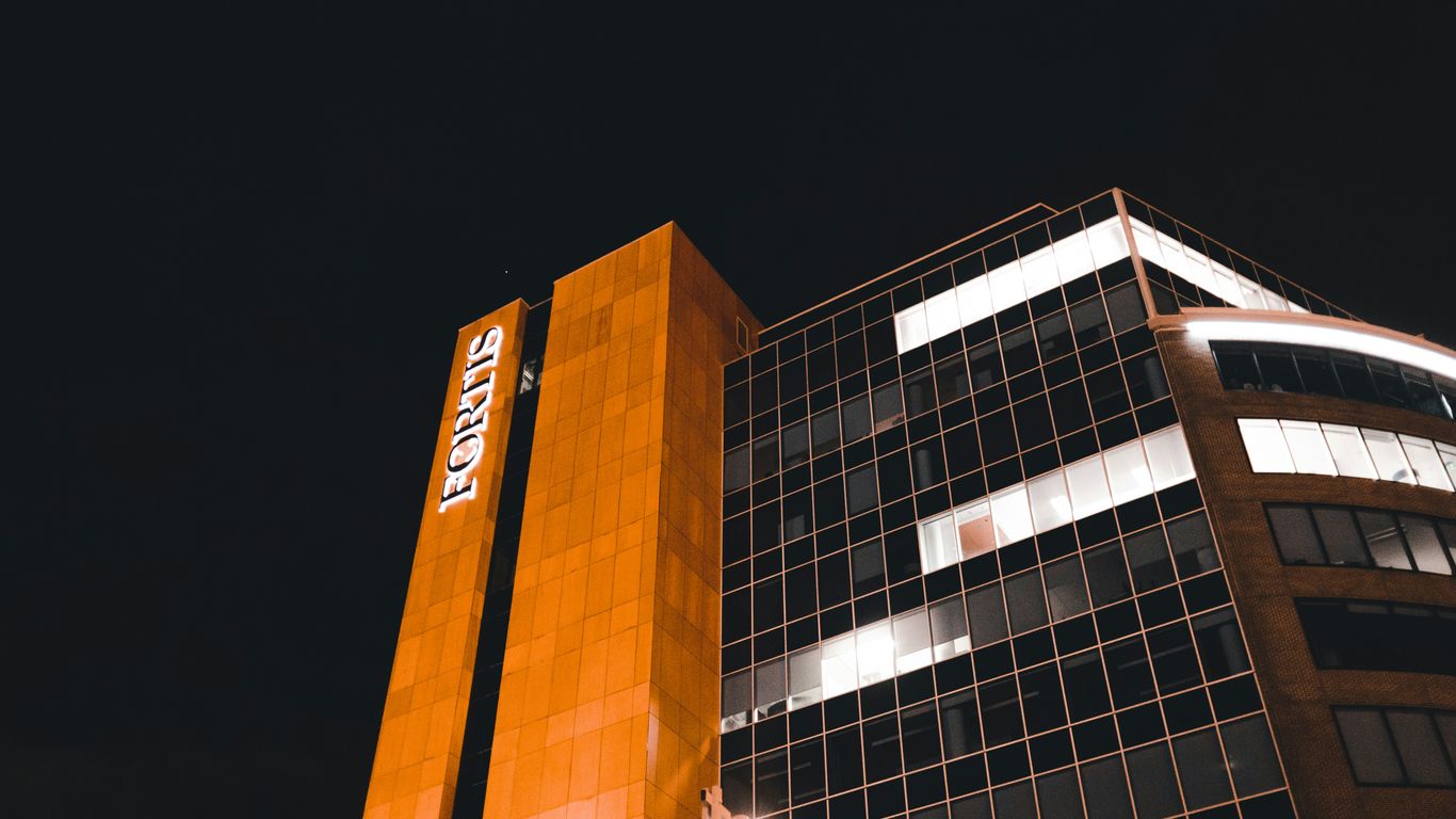 a tall building with a lit up sign on it's side