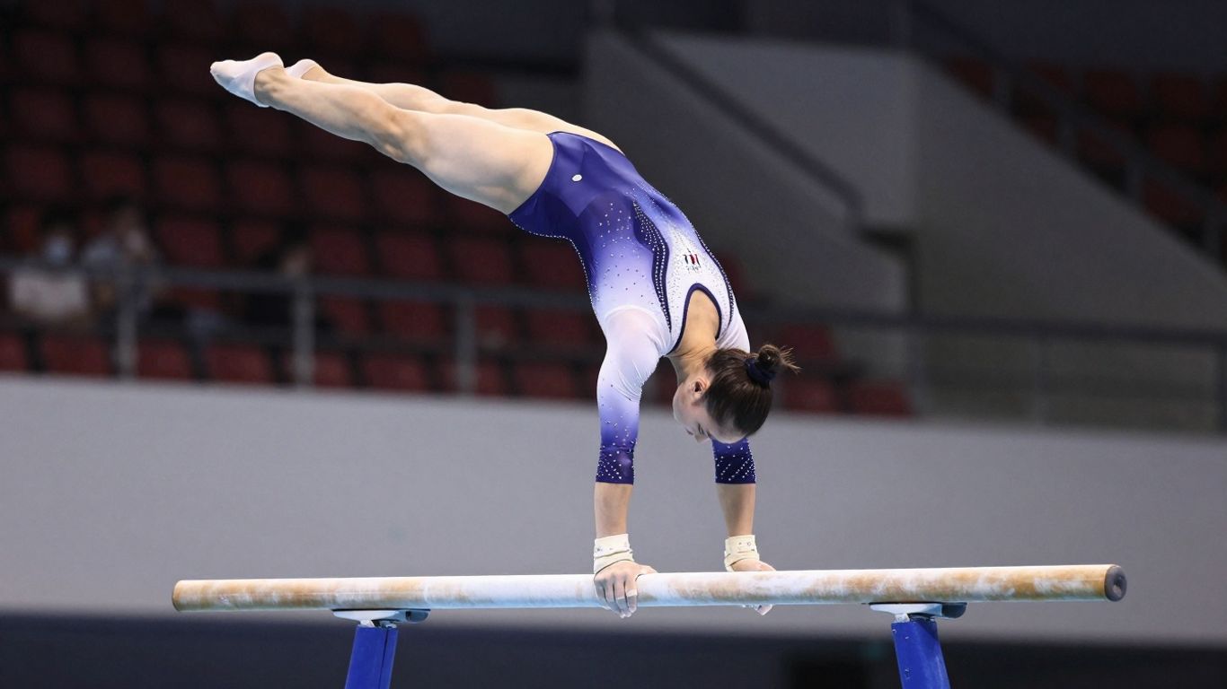 Gimnastă artistică în acțiune pe un aparat.