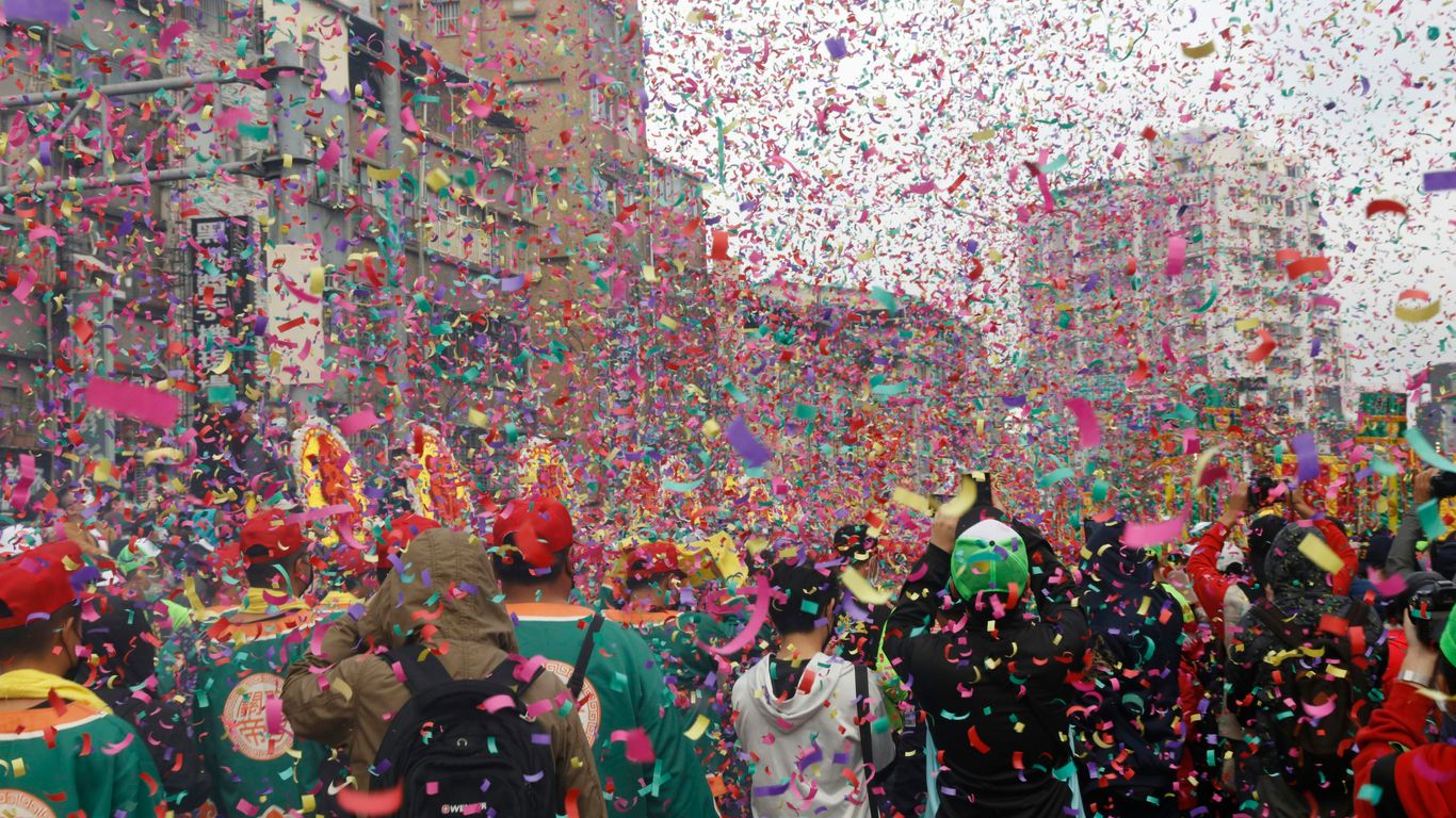 a group of people walking down a street surrounded by confetti