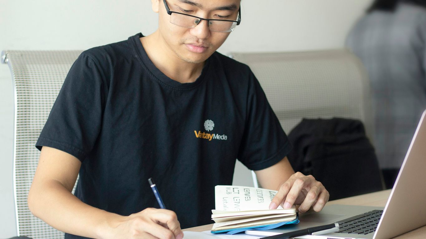 man writing on paper