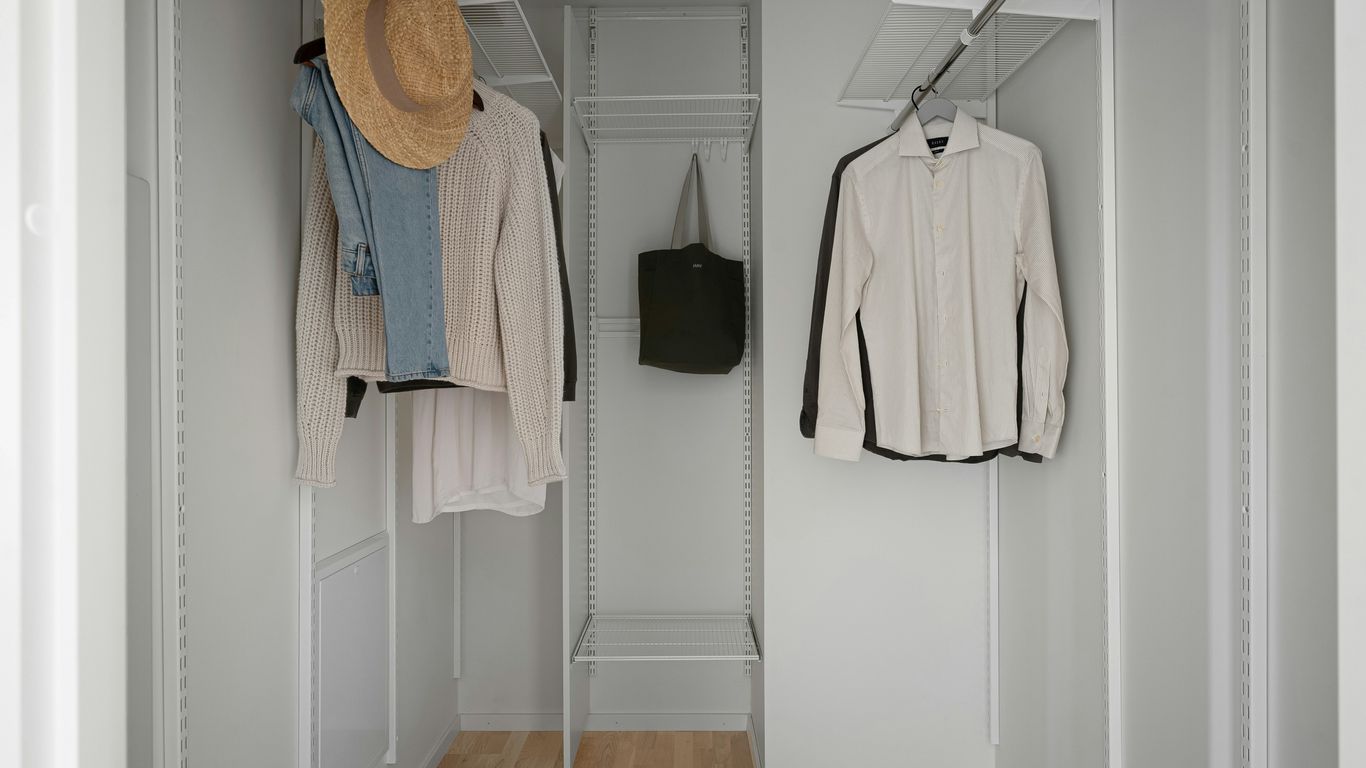 A white closet with a hat and coat rack