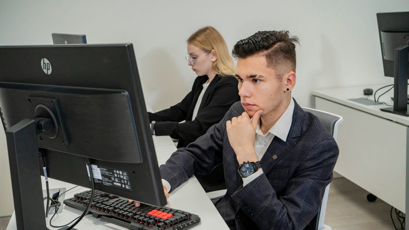 a man sitting at a desk in front of a computer