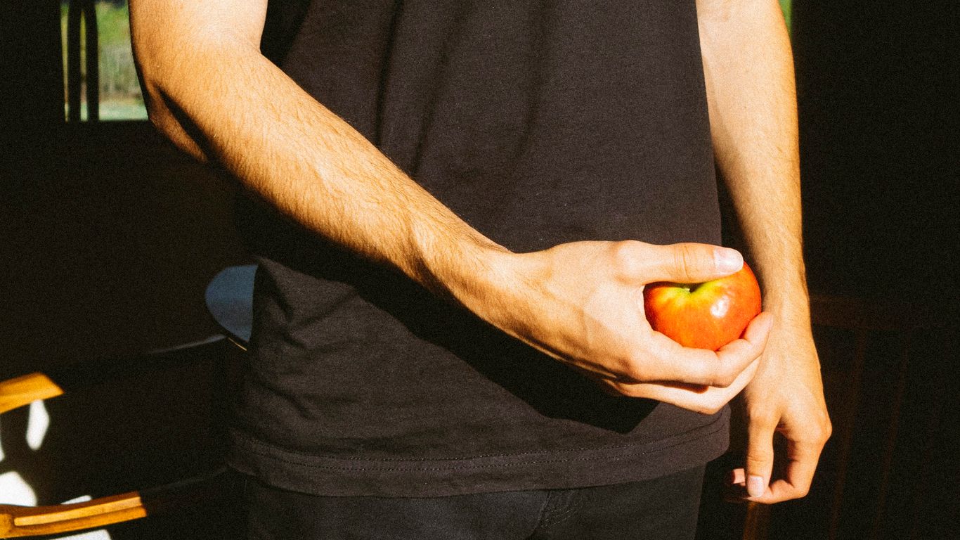 person holding orange and yellow round fruit