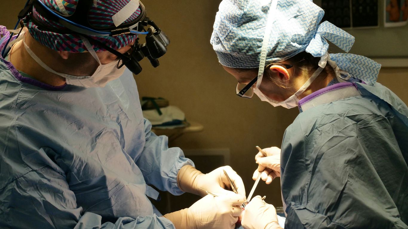 Surgeons performing a medical procedure in an operating room.
