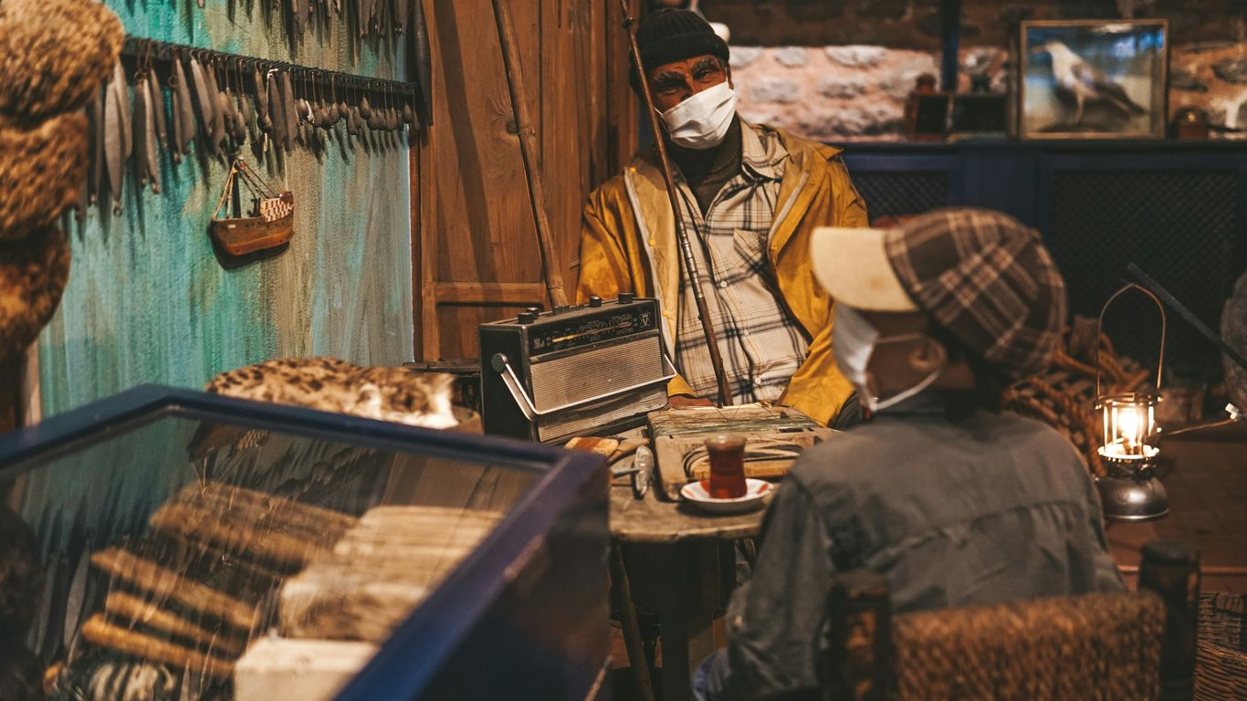 a man wearing a face mask sitting at a table
