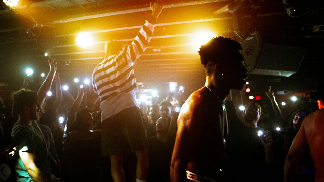 a man on a stage with a microphone and people around him