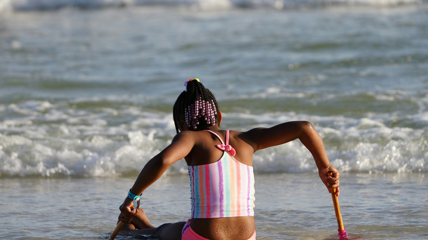 a woman in a bathing suit sitting on the beach