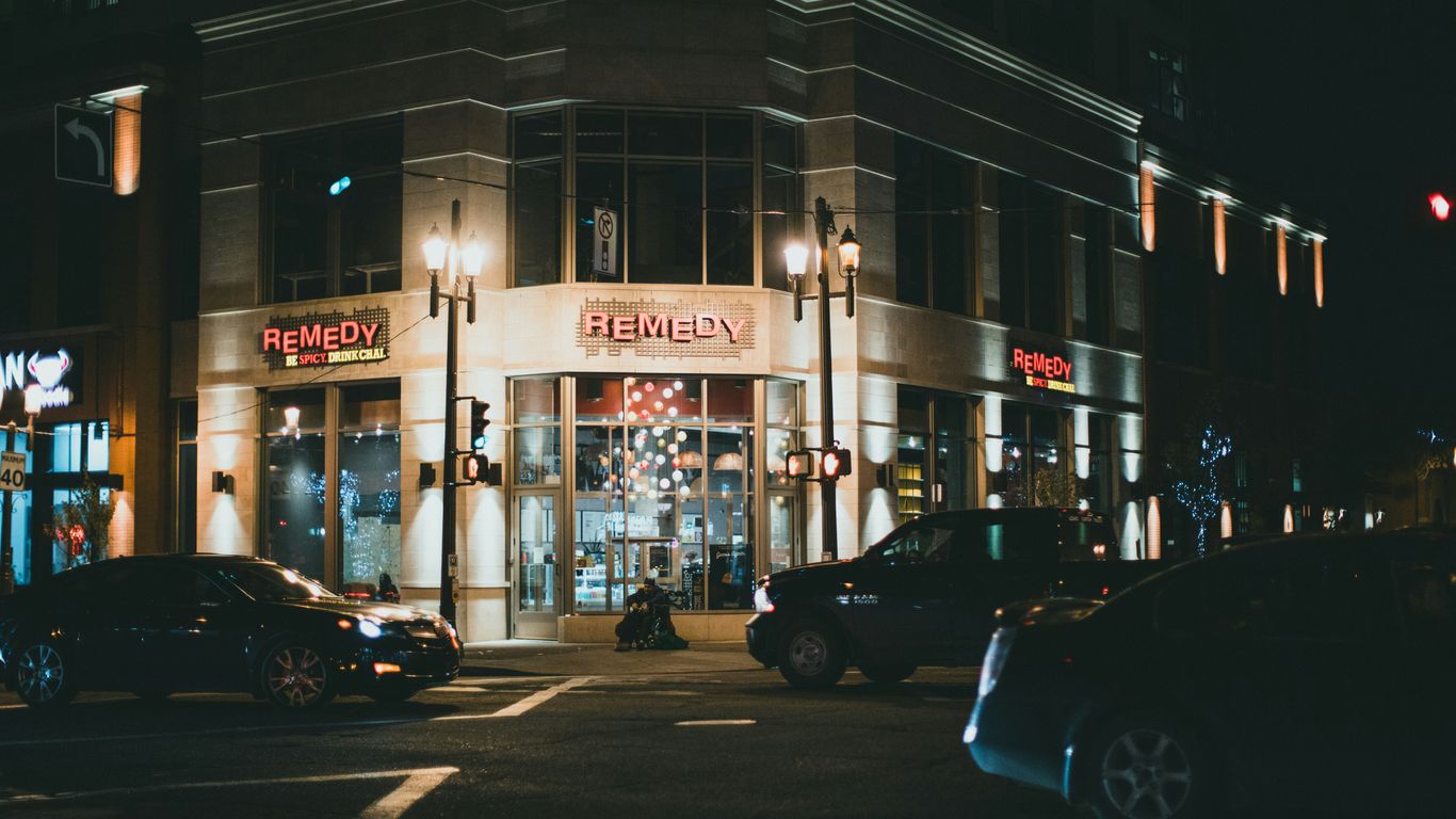 a city street at night with cars parked on the side of the street