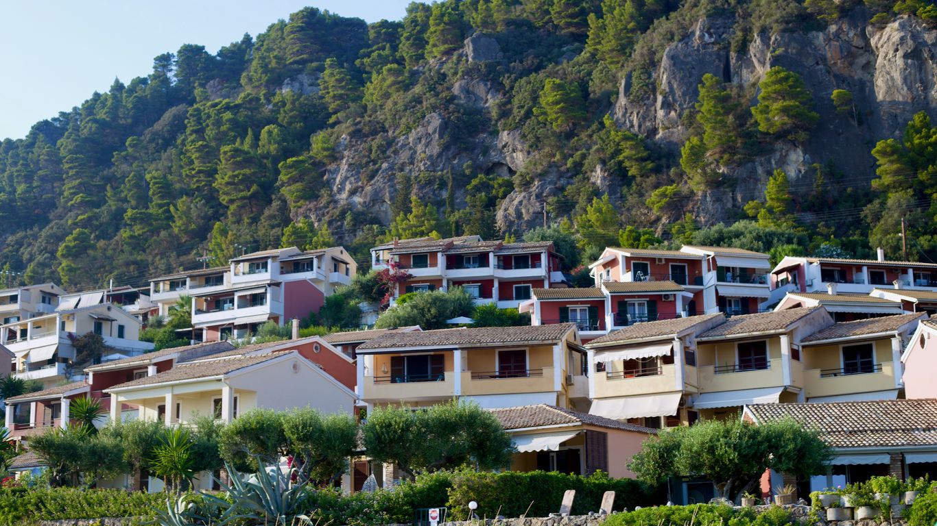 A row of houses on a hillside with a mountain in the background