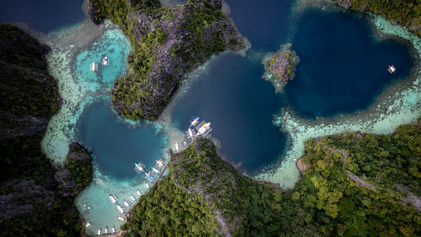 Aerial view of boats docked in a tropical island lagoon.