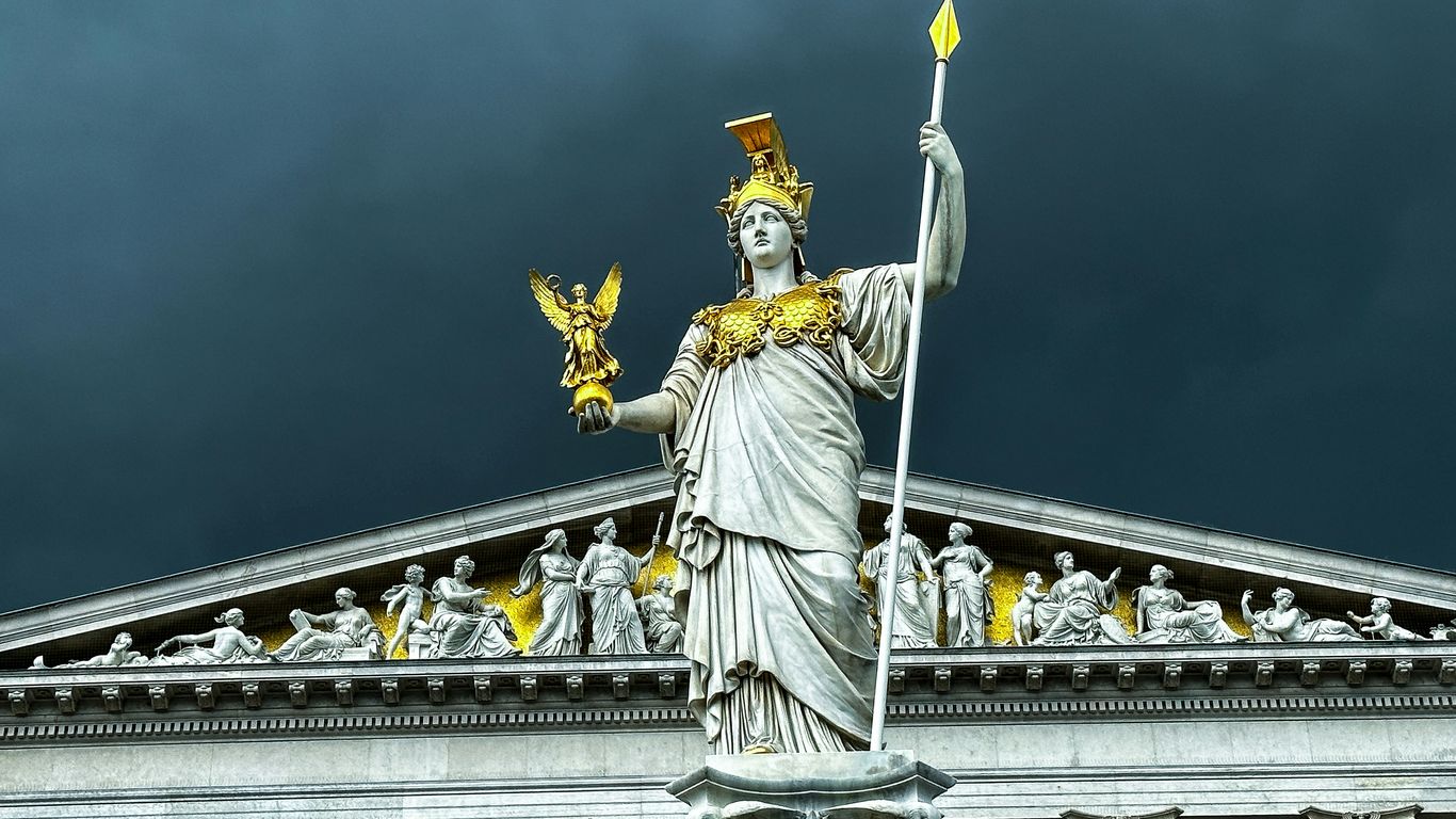 The statue of liberty stands in front of a building