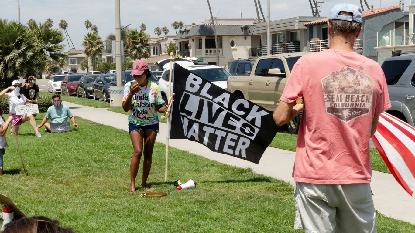 man in pink crew neck t-shirt holding white and black banner
