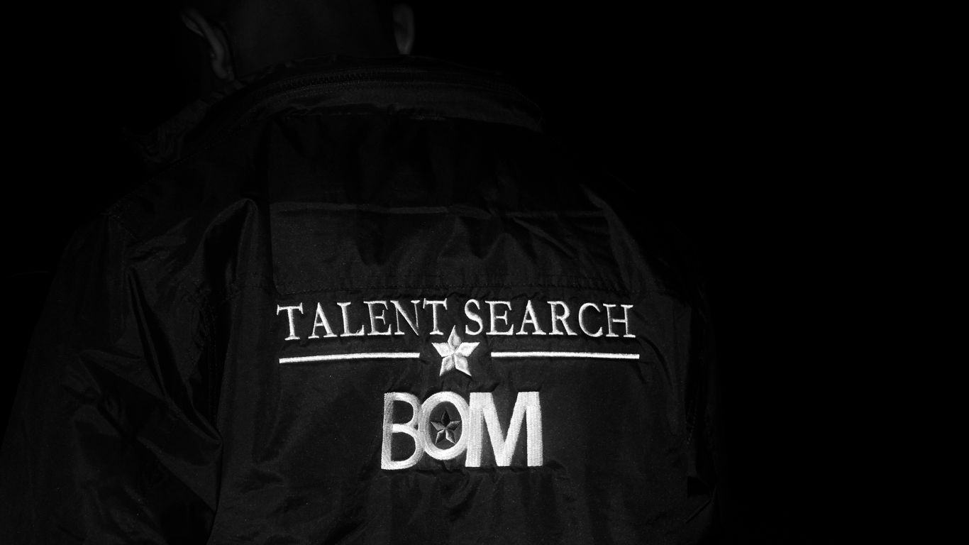 a man in a black jacket with the word talent search on it