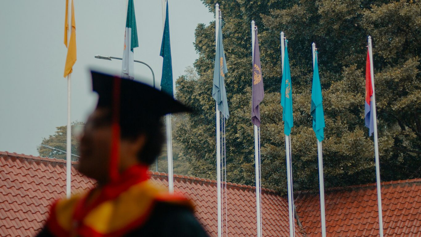 Graduation ceremony with flags and student in cap