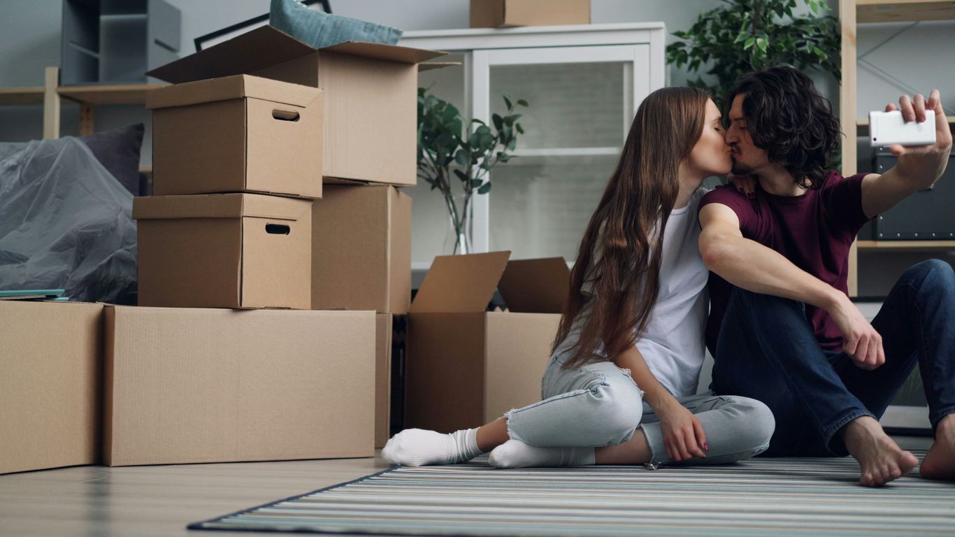 a man and woman sitting on the floor kissing