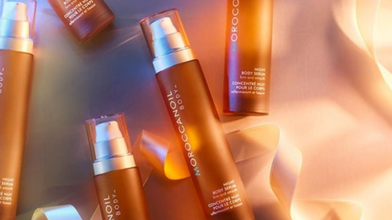 Cosmetic bottles with golden hues and reflective light. Moroccanoil products.