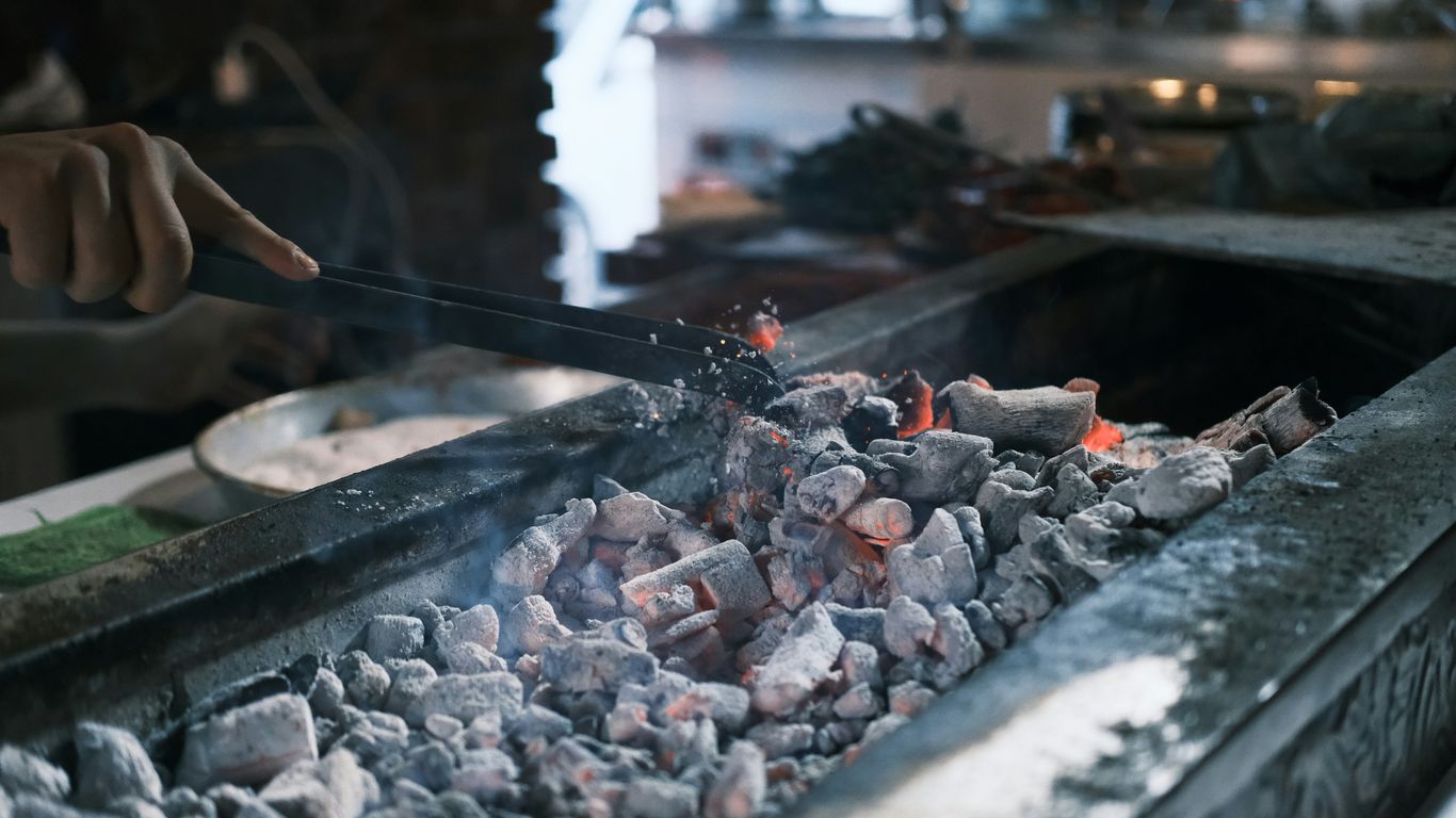 A person cooking food on a grill in a kitchen