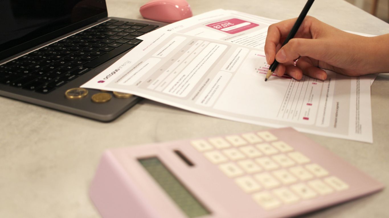 Someone is working on paperwork with a calculator.