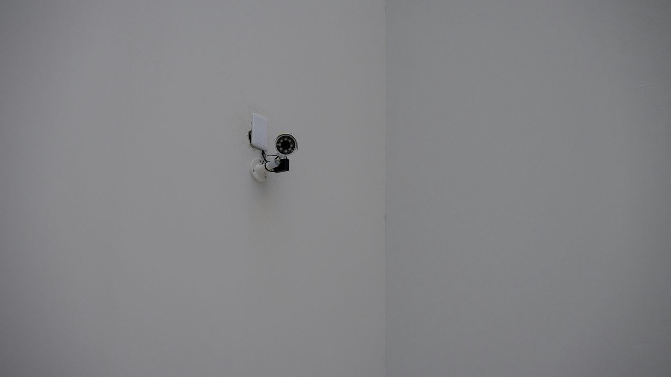 A security camera mounted in a white corner.