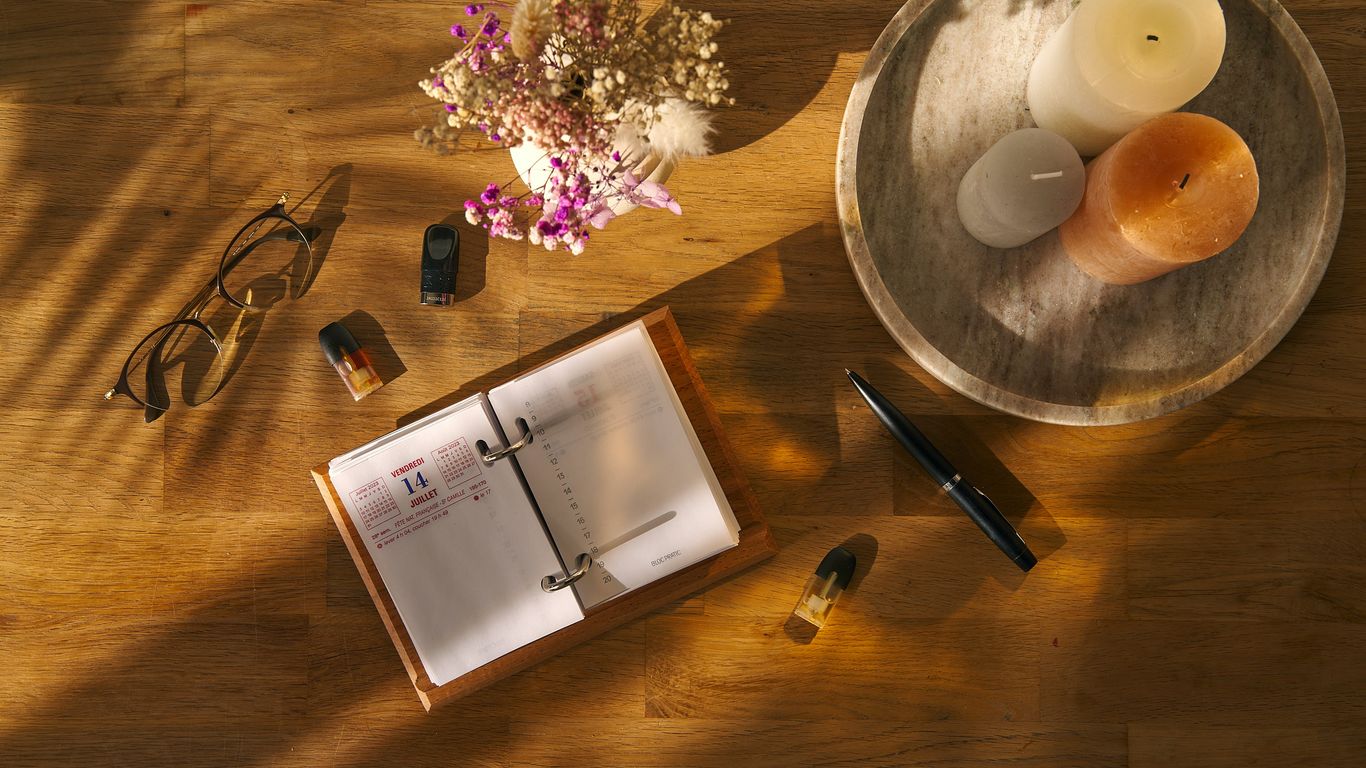 a wooden table topped with a book and a candle