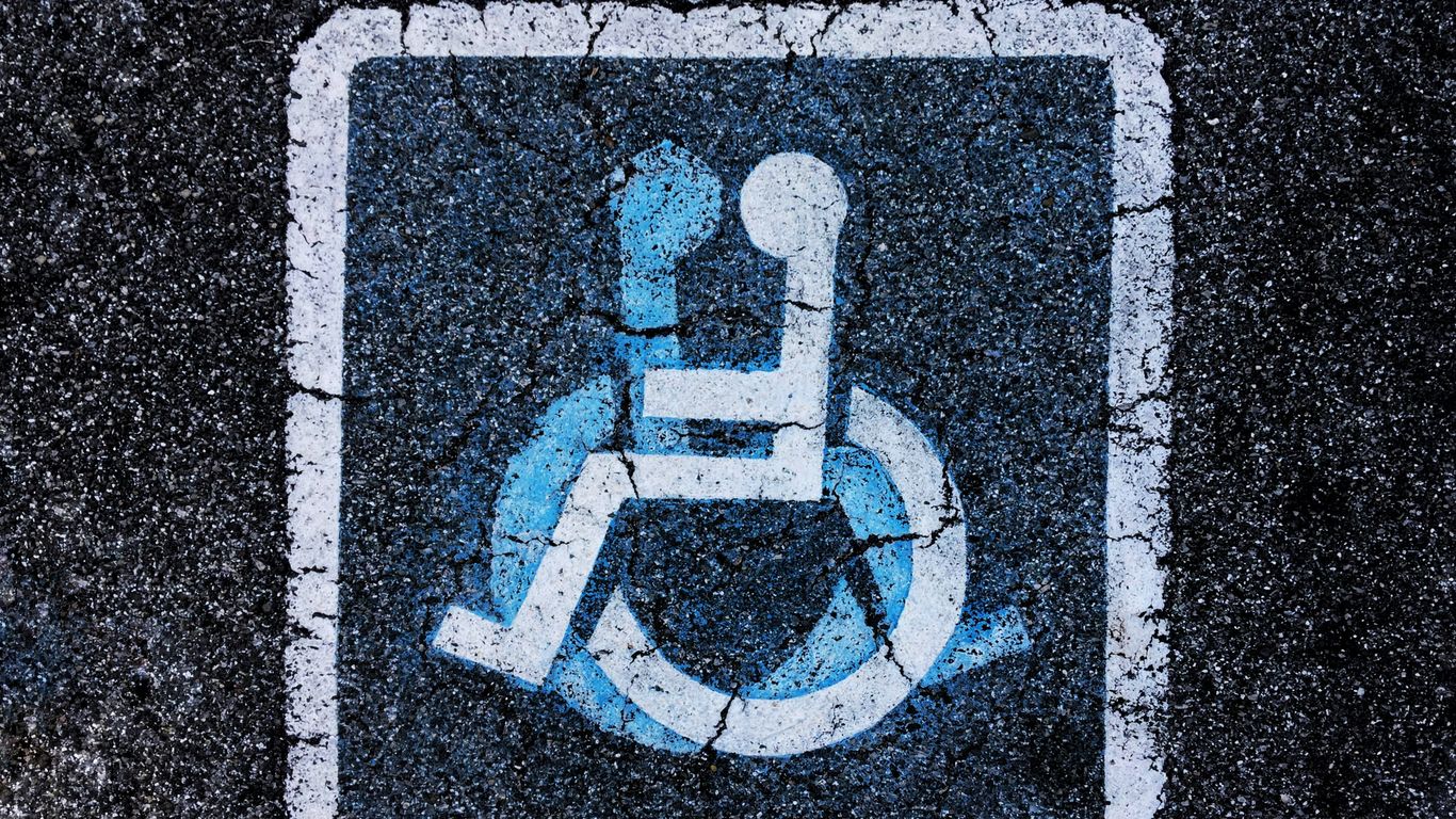 man in red shirt and blue pants sitting on red and black skateboard