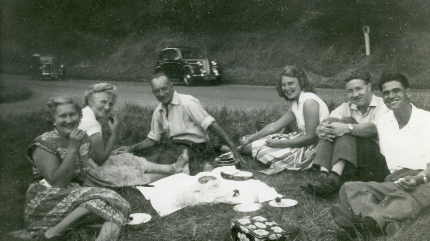 grayscale photo of 4 men sitting on grass