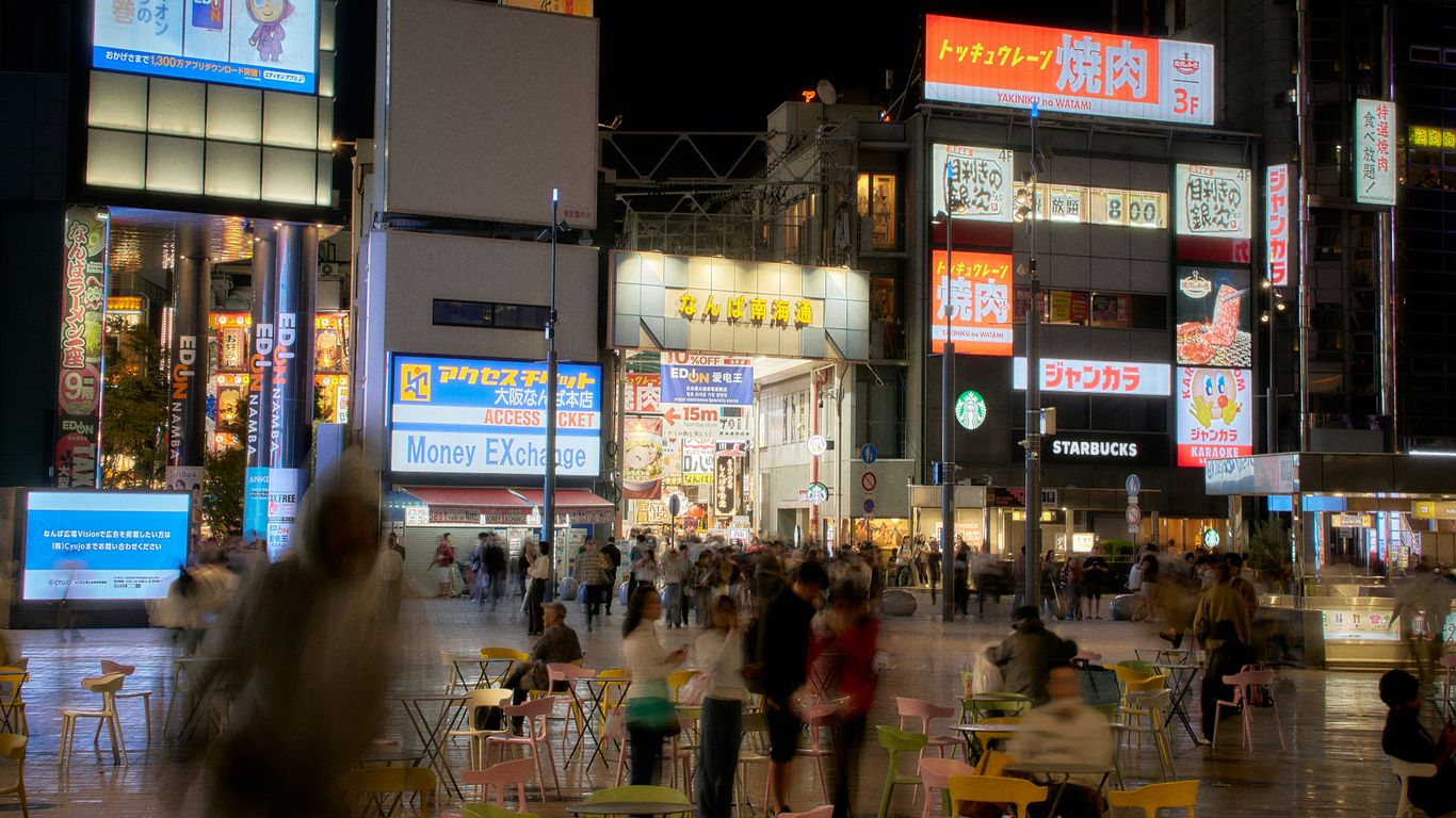 Busy city street at night with glowing signs