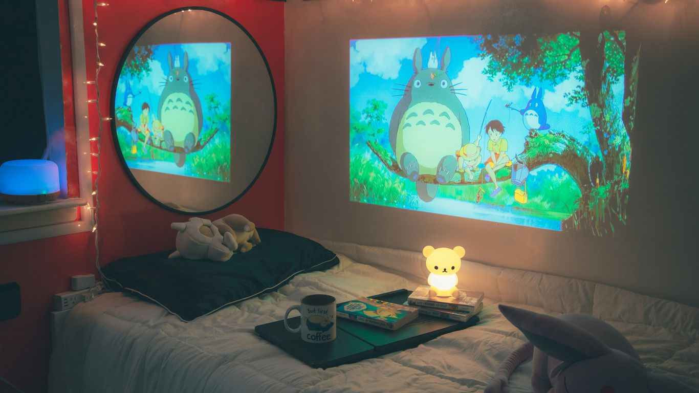 a bedroom with a bed and two large screens on the wall