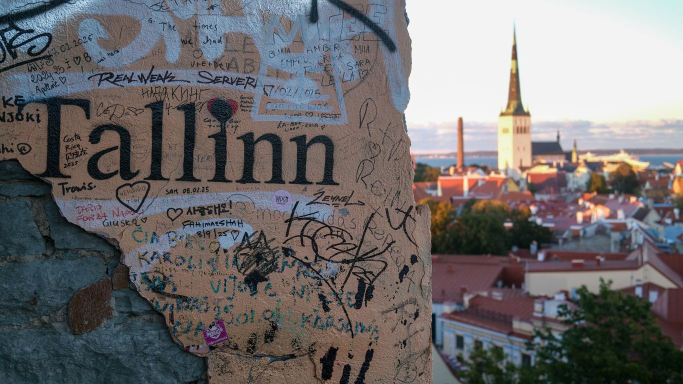 Graffiti on wall with tallinn cityscape in background