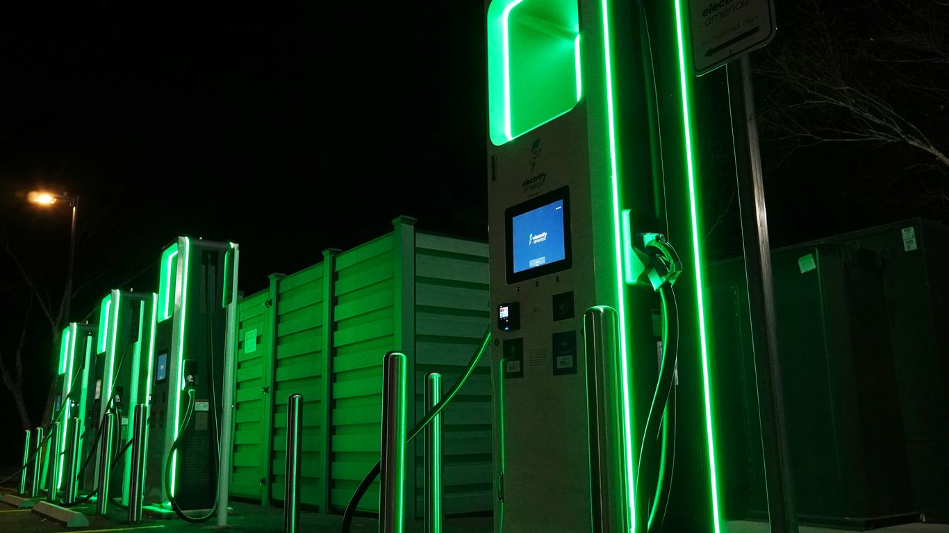 a row of green gas pumps at night