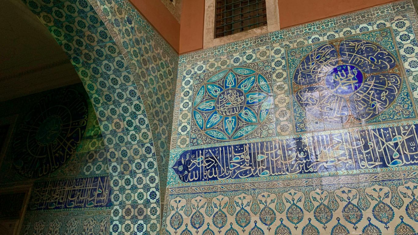 a decorative wall with blue and white tiles