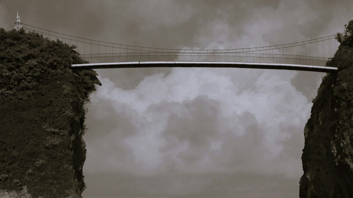 a bridge over a body of water under a cloudy sky