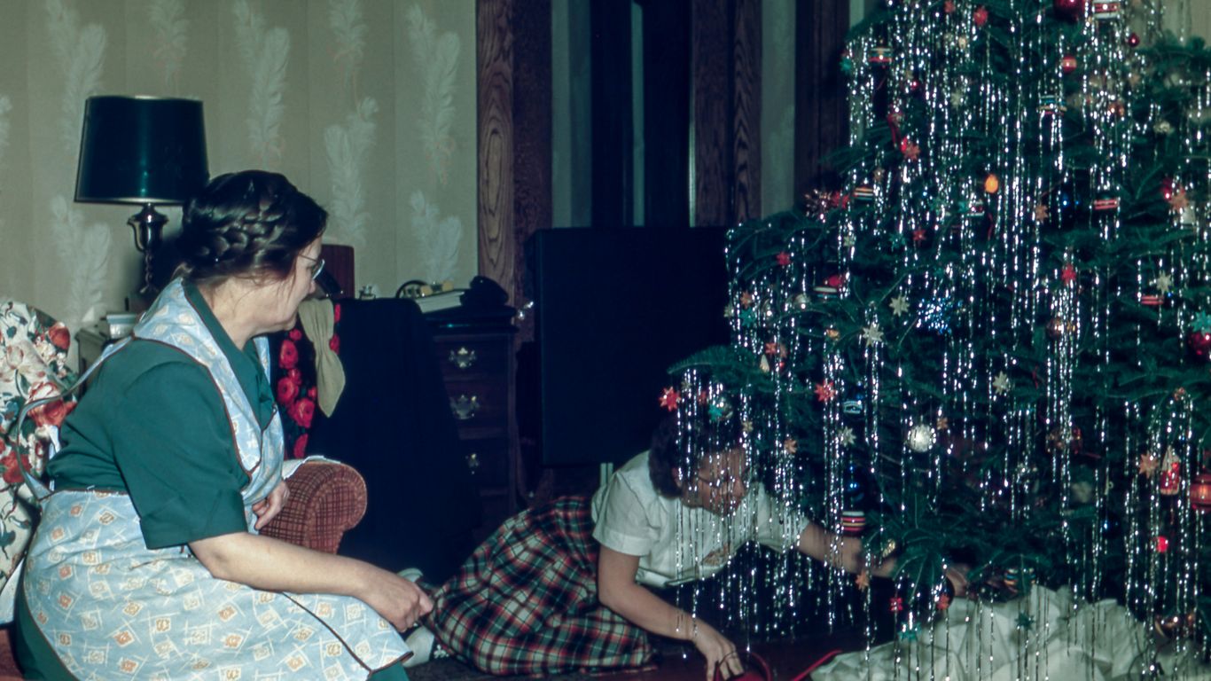 woman sitting under Christmas tree