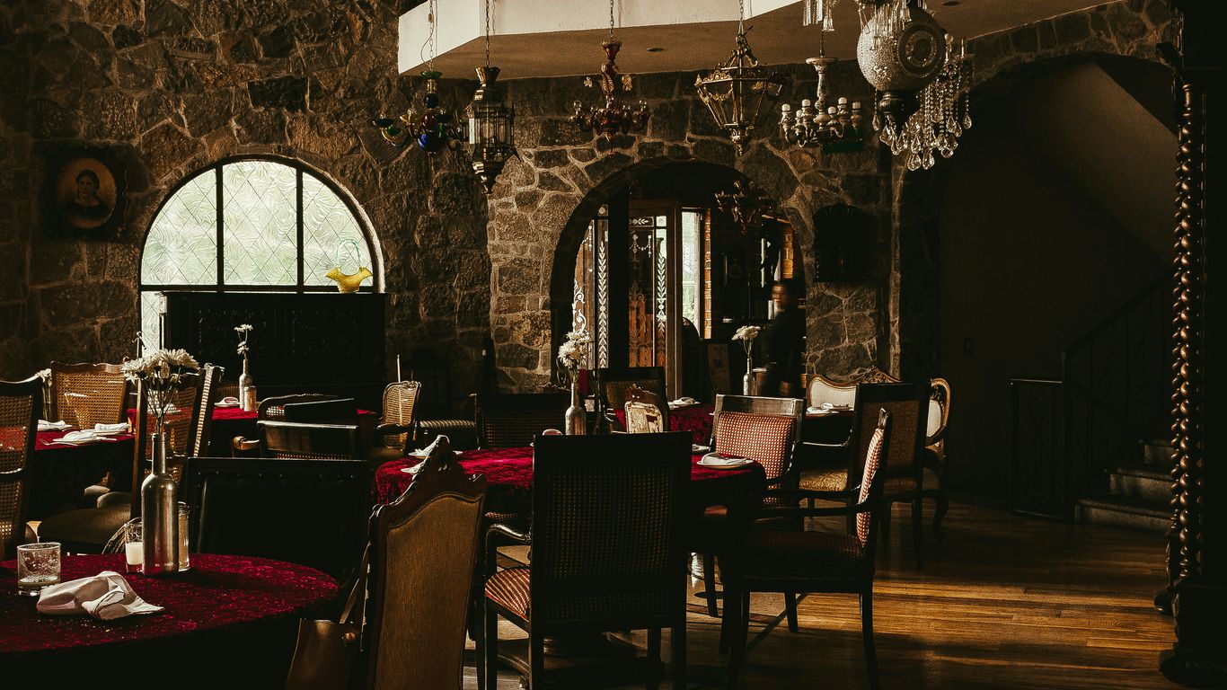 table and chairs inside a dark restaurant room
