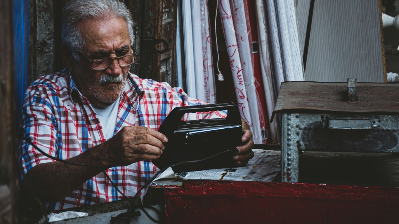 an old man is looking at a wallet