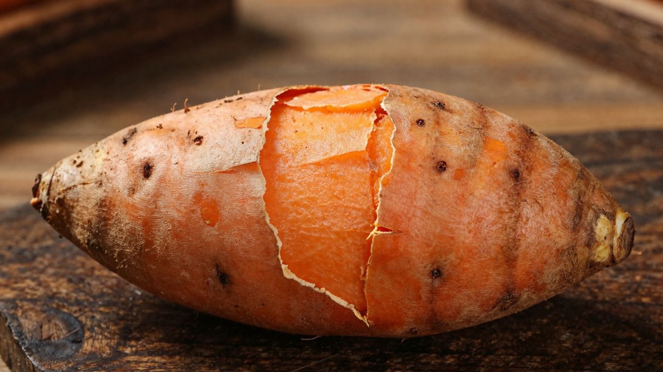 Biologische zoete aardappel op houten ondergrond