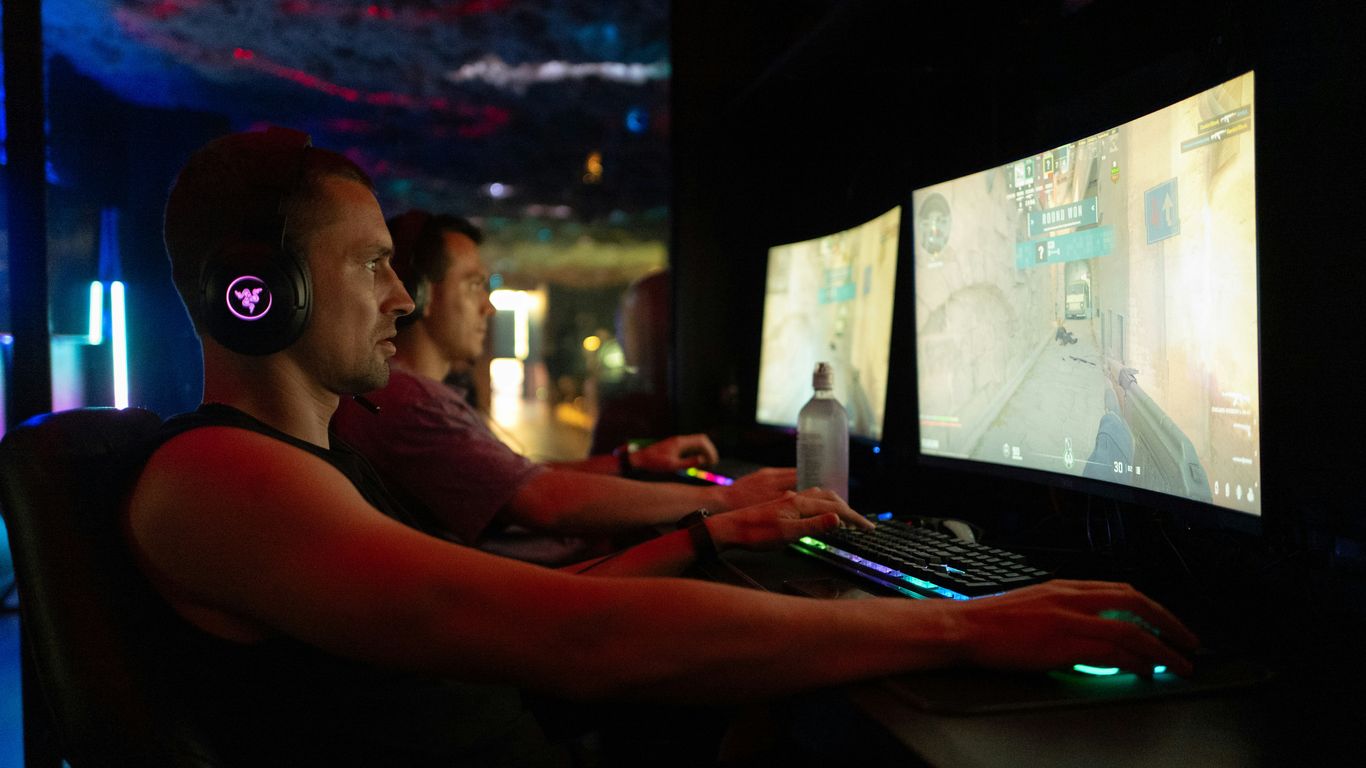 Two men playing video games on computers