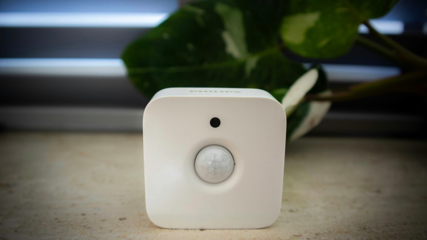 A white sensor sits in front of foliage.