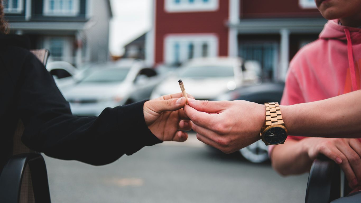 person in black long sleeve shirt holding cigarette stick